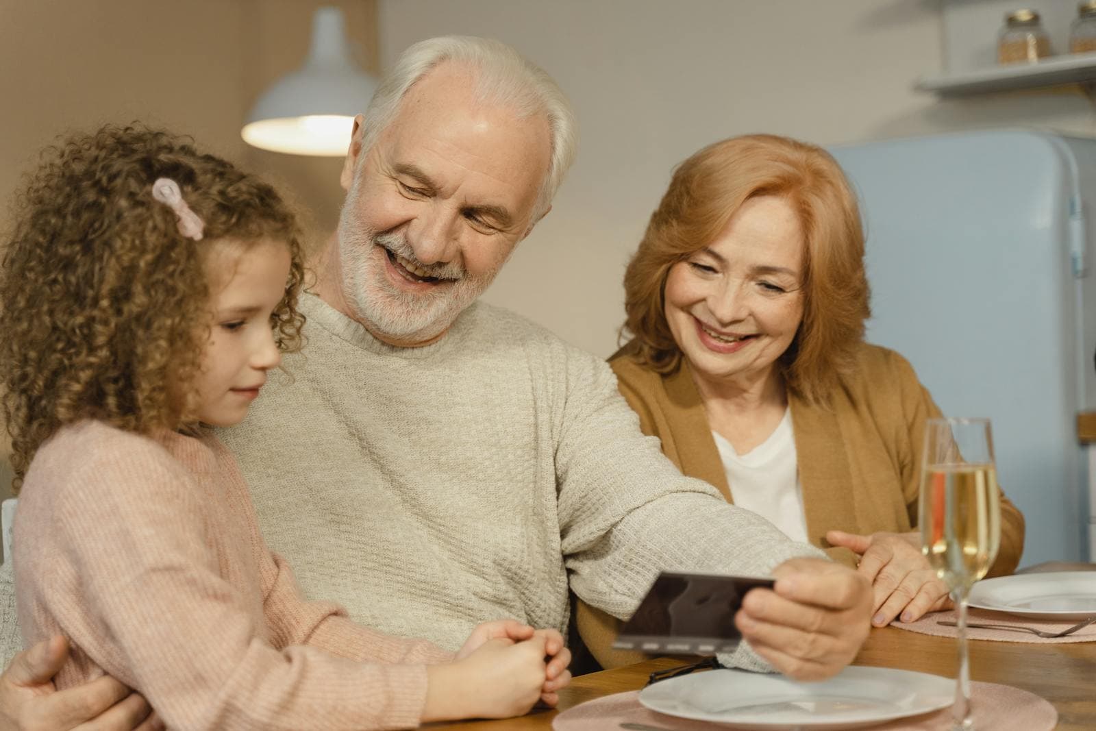 Smiling grandparents enjoy time with their granddaughter at home — the goal of well-chosen elder care services.